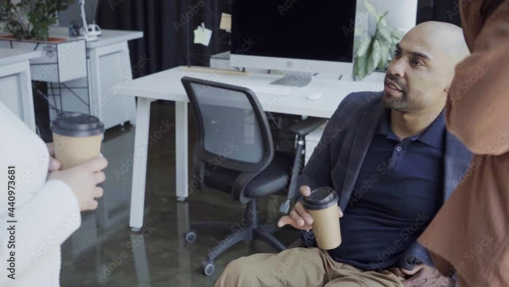 handicapped african american boss talking with coworkers in office handicapped african american boss talking with coworkers in office