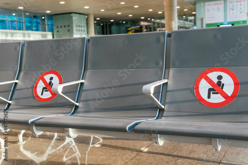 Empty seats in airport with social distancing stickers