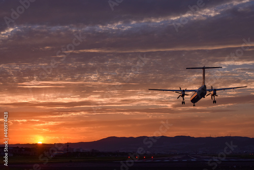 美しい夕焼けに着陸する飛行機