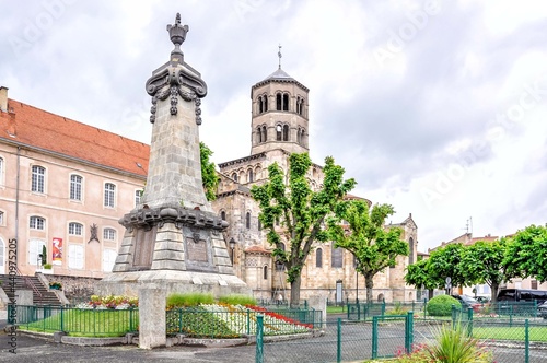 Issoire, a town in the land of the volcanoes of Auvergne, France! View of the war memorial in the foreground and the 12th-century Sainte-Austremoine Church in the background 