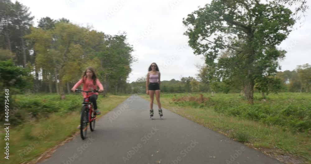 pretty foillette on bike accompanied by her sister on roller skate pretty foillette on bike accompanied by her sister on roller skate