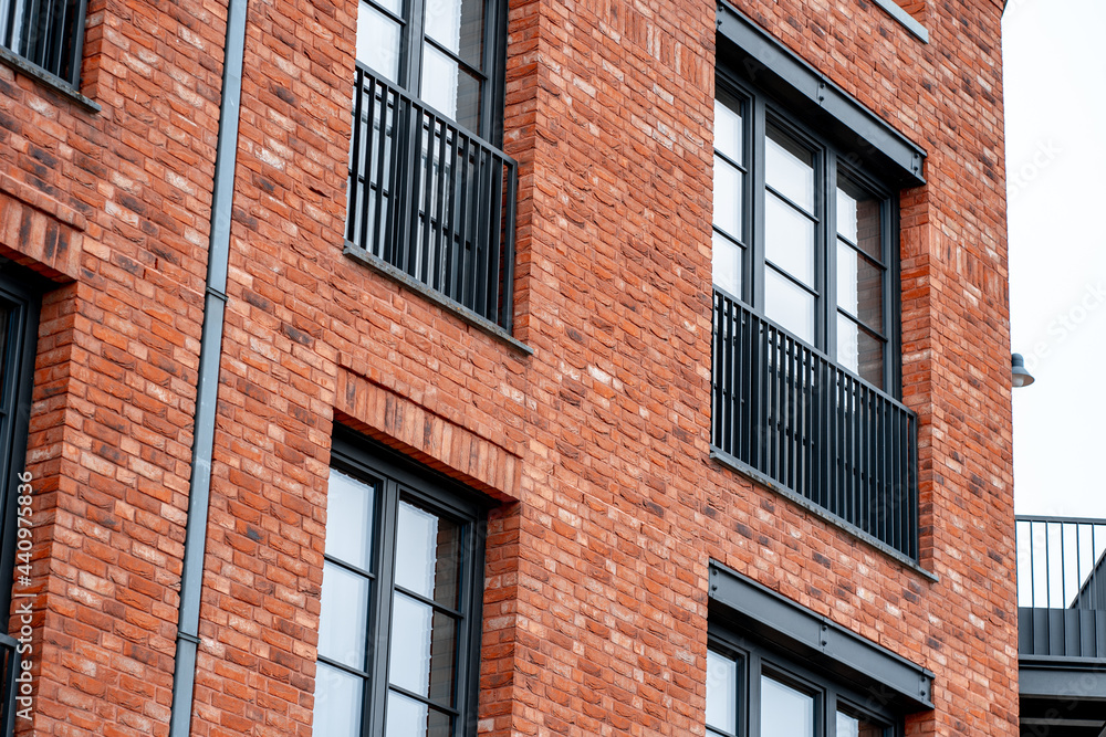 Red brick wall of modern residential building with large windows (896)