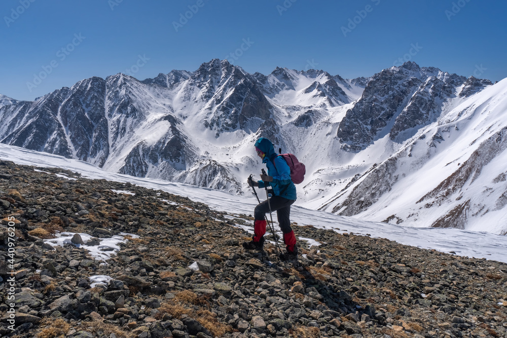 Girl with a backpack climbs the mountain