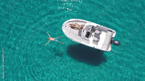 Aerial - Young couple enjoying their day on a boat on a beautiful turquoise sea