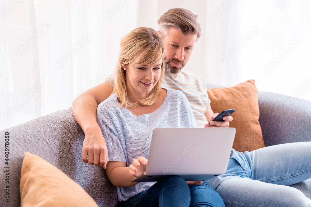 Smiling couple relaxing on the sofa at home Smiling couple relaxing on the sofa at home