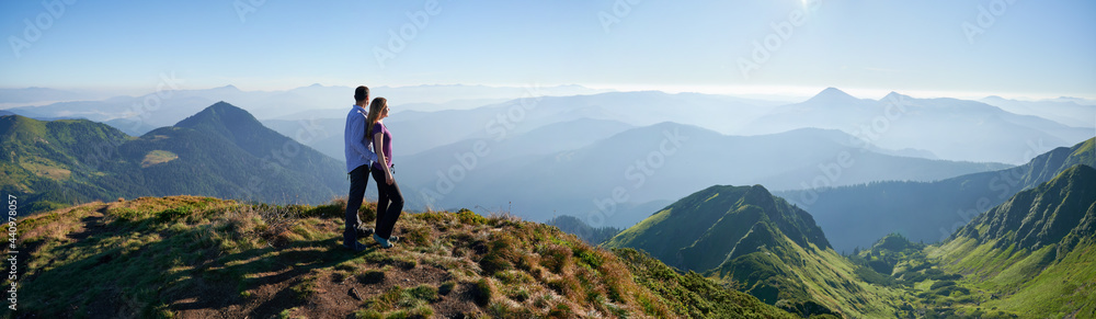 Side view of romantic couple relaxing on fresh air with incredible landscape. Concept of harmony with nature. Panorama - obrazy, fototapety, plakaty 