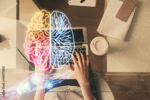 Double exposure of woman working on computer andhuman brain hologram drawing. Top View. Ai concept.