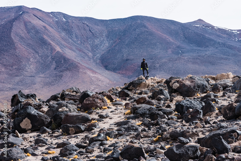 Young man hikes the dry and rocky landscape in Bolivia