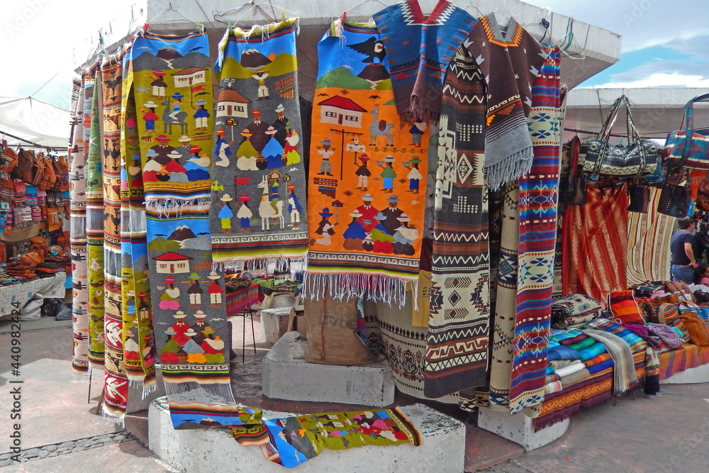 Rugs and blankets for sale at an outdoor market in Otavalo, Ecuador.