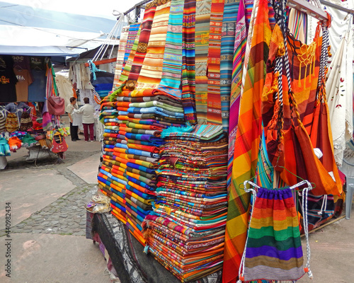 Blankets and clothes for sale at an outdoor market in Otavalo, Ecuador.