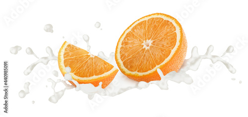 Cutted orange in milk splashes isolated on white background.