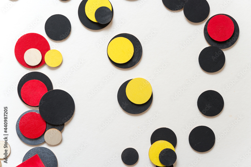 laser-cut plywood shapes hand painted in red, yellow, silver black, and flat black with some natural pieces loosely arranged on white - photographed from above in a flat lay style