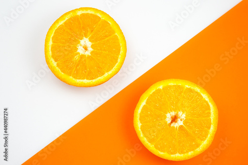 Close up photo of Orange Fruit on the white and orange background. Citrus cut in half  inside  macro view. Minimalism  original and creative image. Beautiful natural wallpaper.