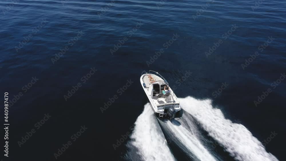 Aerial - Couple enjoying summer speeding on a motorboat