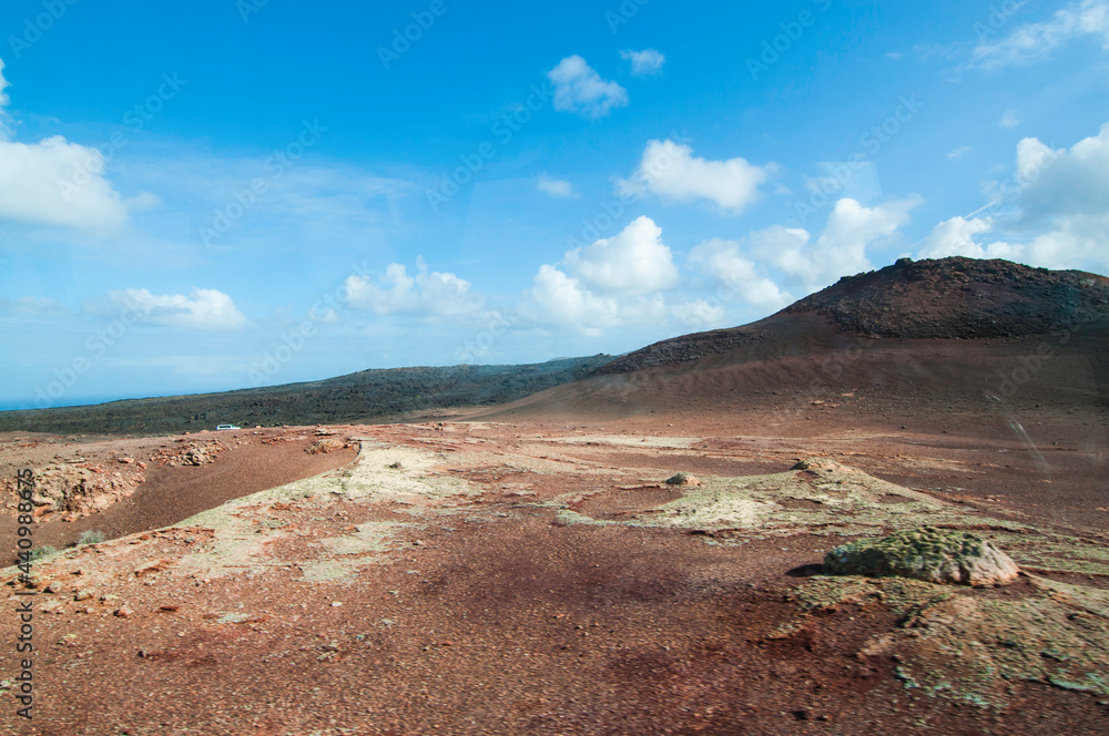 Spanien, Kanaren, Lanzarote. Blick über eine vulkanisch geprägte Landschaft. Typische karge rotgefärbte Landschaft