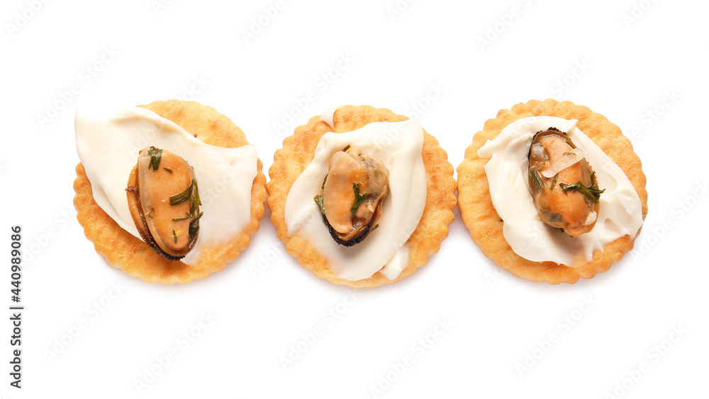 Tasty crackers with mussels and cheese on white background