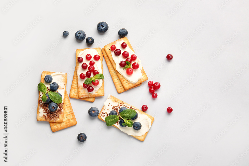 Fotografie Tasty crackers with berries on grey background