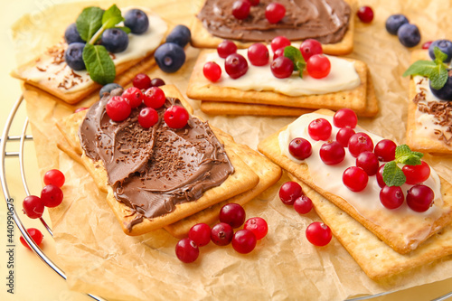 Tasty crackers with berries on table, closeup