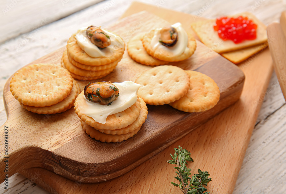 Tasty crackers with cheese and mussels on light wooden background, closeup Tasty crackers with cheese and mussels on light wooden background, closeup
