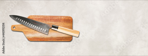 Traditional Japanese gyuto chief knife on a cutting board. White concrete background banner photo