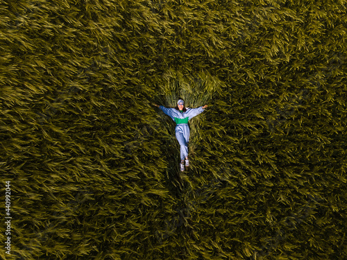 smiling woman laying down in wheat field