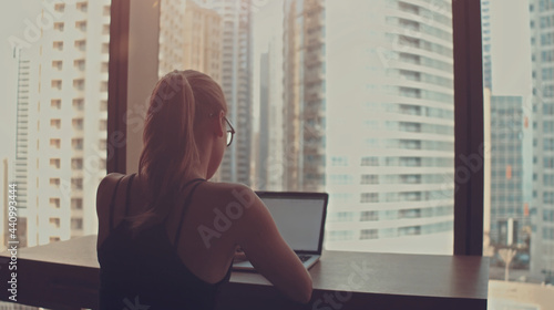 Beautiful Successful Businesswoman Working on a Laptop in Her Office with Cityscape View Window. Strong Independend Female CEO Runs Business Company. 