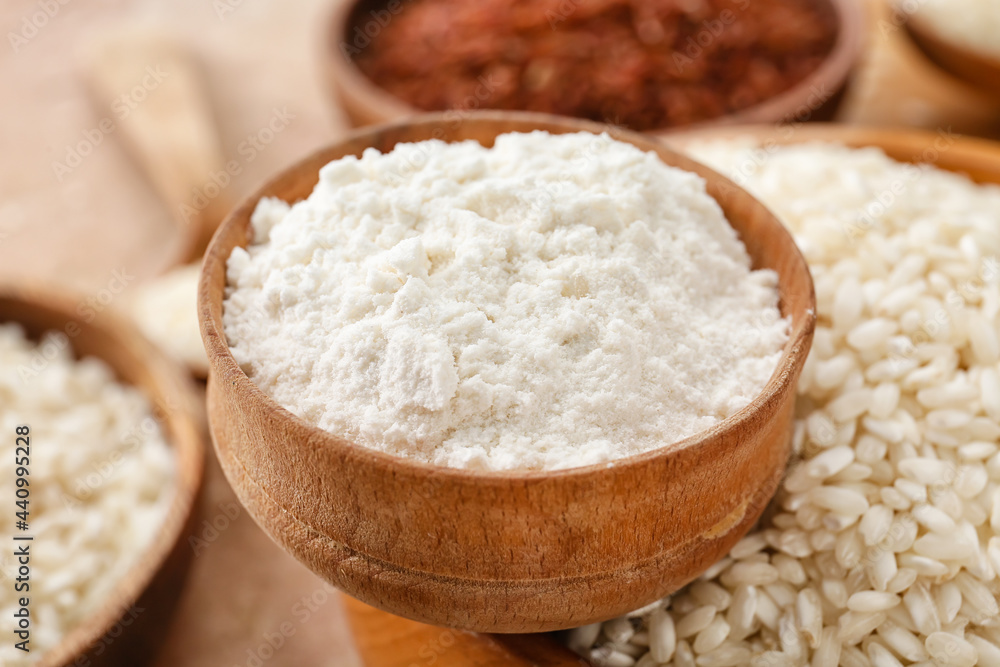 Different types of raw rice and flour on color background, closeup