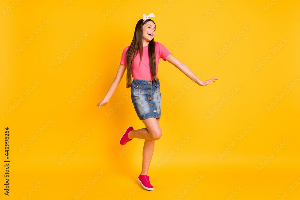 Photo of adorable shiny small schoolgirl dressed pink t-shirt dancing smiling isolated yellow color background Photo of adorable shiny small schoolgirl dressed pink t-shirt dancing smiling isolated yellow color background
