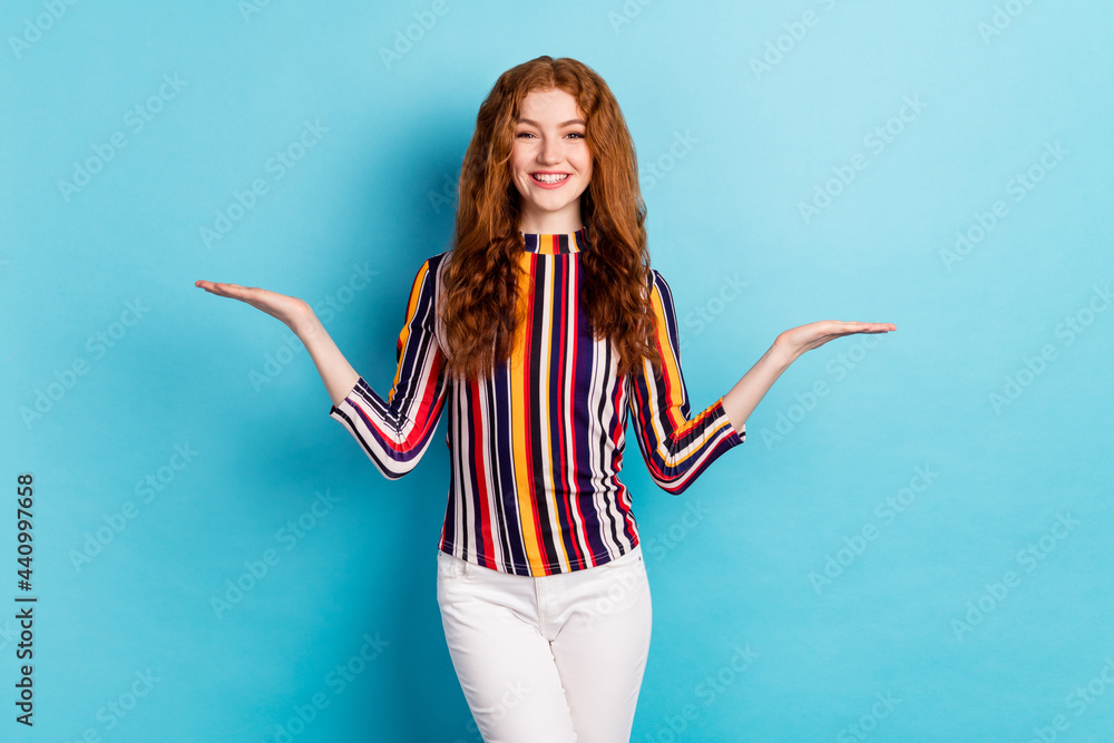 Photo of cool ginger hairdo millennial lady hold empty space wear colorful shirt isolated on blue color background Photo of cool ginger hairdo millennial lady hold empty space wear colorful shirt isolated on blue color background