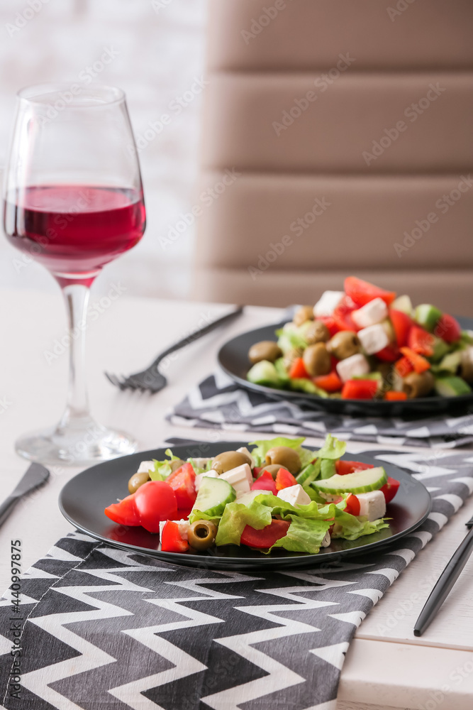 Plates with fresh Greek salad on table in restaurant Plates with fresh Greek salad on table in restaurant