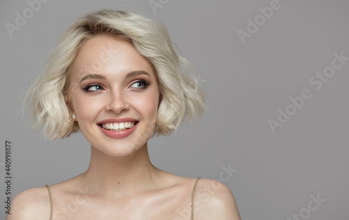 Foto Portrait of a beautiful smiling blonde girl with a short haircut
