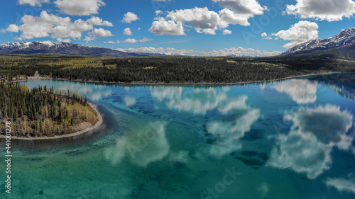 Kathleen Lake, Yukon, Canada. Taken in the summertime with stunning emerald, turquoise green reflective water with blue sky clouds and wild boreal forest. Beautiful Canadian landscape in nature.  photo