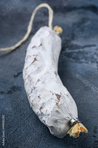 Whole spanish salchichon sausage on blue background © Ilia Nesolenyi