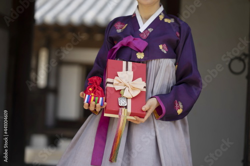 Woman in Korean traditional clothes holding lucky bag with gift box