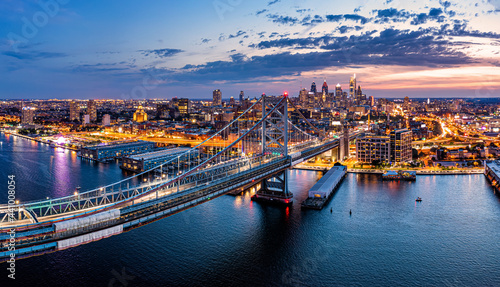 Aerial panorama with Ben Franklin Bridge and Philadelphia skyline in transition from sunset to dusk. Ben Franklin Bridge is a suspension bridge connecting Philadelphia and Camden, NJ. photo