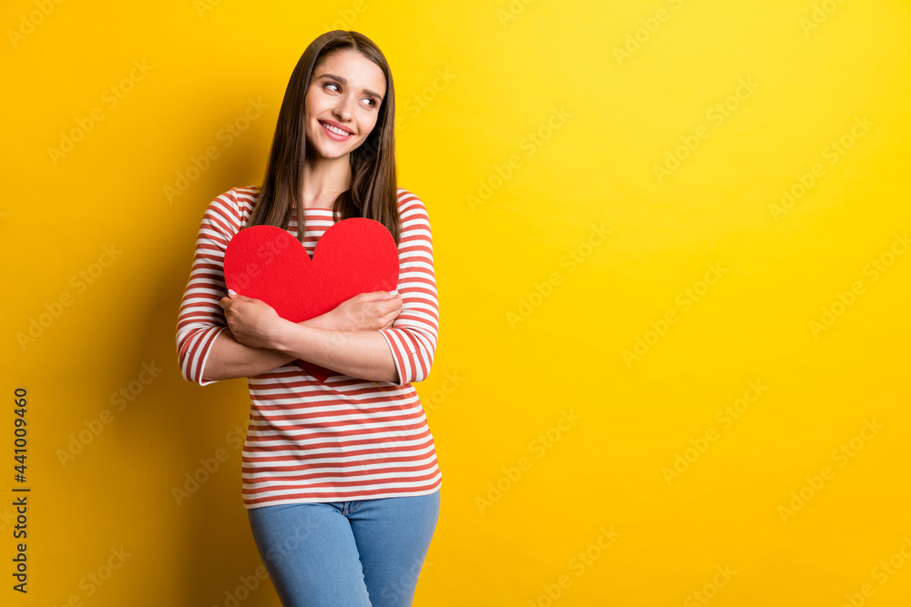 Portrait of attractive cheerful girl hugging heart card health care medicine look copy space isolated over bright yellow color background Portrait of attractive cheerful girl hugging heart card health care medicine look copy space isolated over bright yellow color background