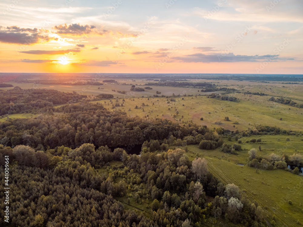 Calm landscape of forests and fields during the sunset. Rural landscape made with a drone