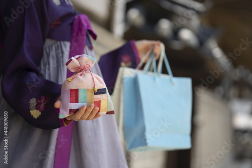 Woman in Korean traditional clothes holding lucky bag with shopping bag