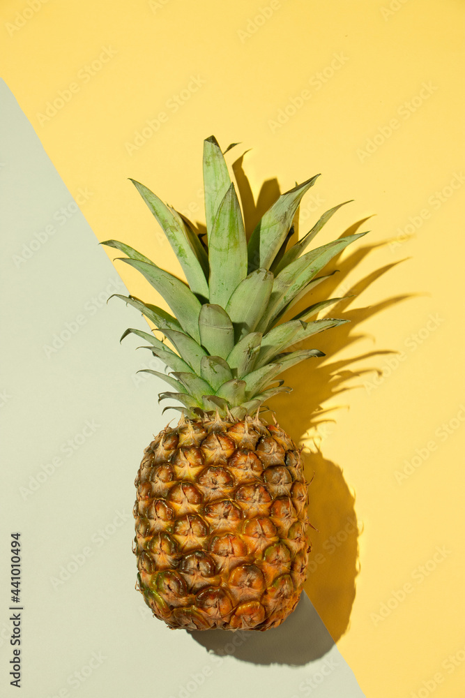 Pineapple on a yellow and gray background, flet lay, summer Pineapple on a yellow and gray background, flet lay, summer