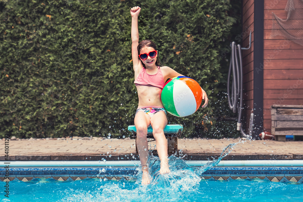 child girl having fun in Pool on the summer time sit on springboard