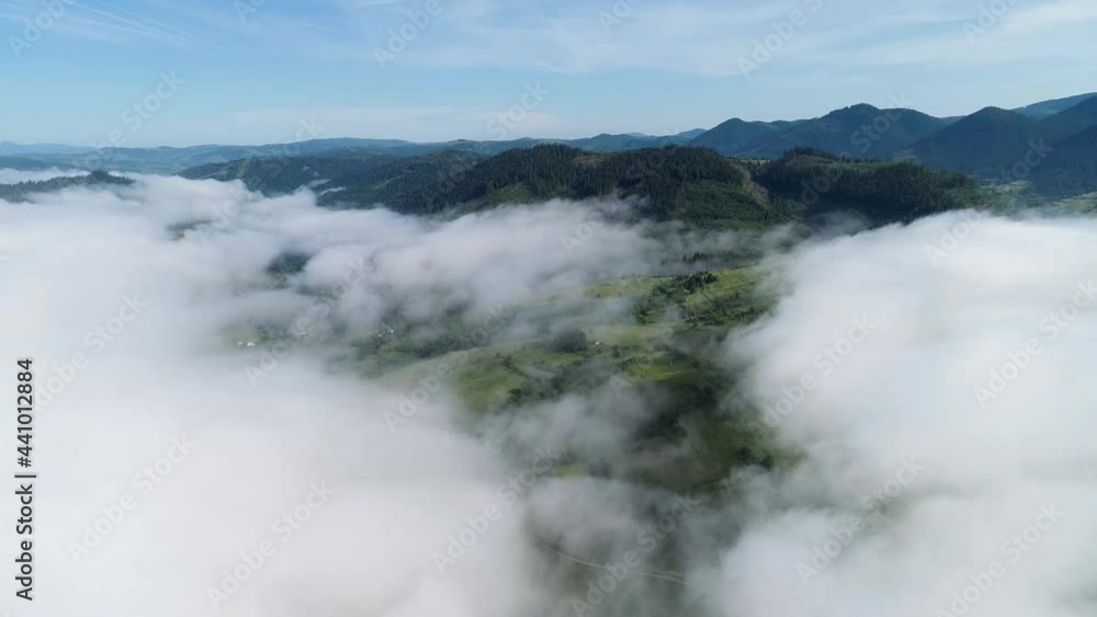 Aerial view of misty foggy morning summer mountains with the clouds floating through the pine forest trees. Rolling hills and mountain peaks. Above the clouds in the Carpathian Mountains. 4k Aerial view of misty foggy morning summer mountains with the clouds floating through the pine forest trees. Rolling hills and mountain peaks. Above the clouds in the Carpathian Mountains. 4k