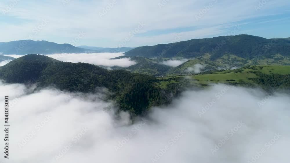 Aerial view of misty foggy morning summer mountains with the clouds floating through the pine forest trees. Rolling hills and mountain peaks. Above the clouds in the Carpathian Mountains. 4k Aerial view of misty foggy morning summer mountains with the clouds floating through the pine forest trees. Rolling hills and mountain peaks. Above the clouds in the Carpathian Mountains. 4k