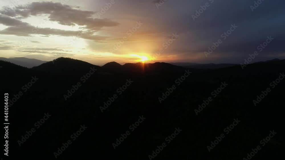 Aerial view of sunset over the Mountain range silhouette. Drone cinematic shot of mountains at orange sunset in summer. Sun rays. Dark sunrise aerial view of Carpathian Mountain in Ukraine. Aerial view of sunset over the Mountain range silhouette. Drone cinematic shot of mountains at orange sunset in summer. Sun rays. Dark sunrise aerial view of Carpathian Mountain in Ukraine.