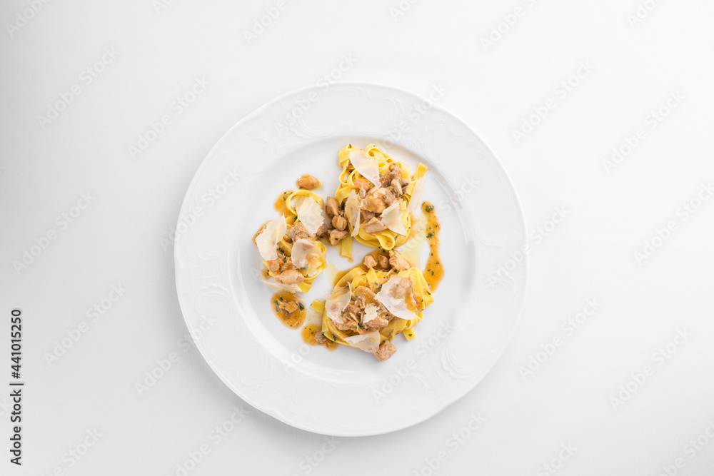 Fettuccine pasta with chicken and cheese on white plate isolated on white background Fettuccine pasta with chicken and cheese on white plate isolated on white background