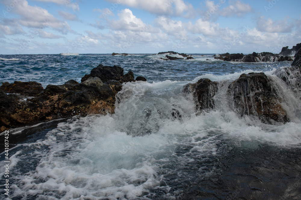 Splashing waves on the rock in the sea. Wave hit the stone in the ocean with a water background.