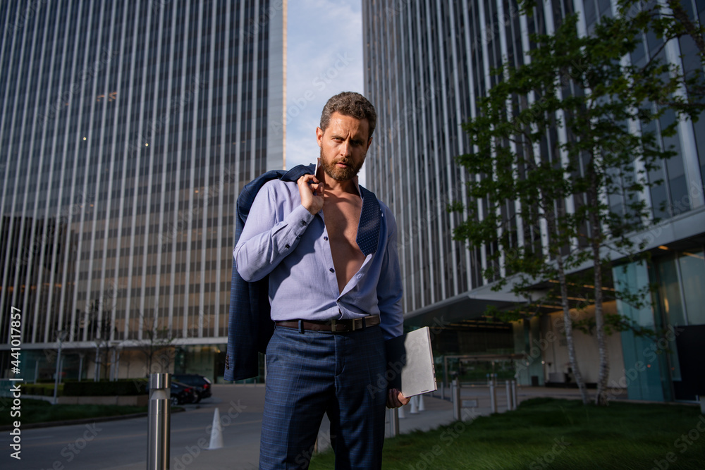 Caucasian business man in suit comes out office. concept of end working day. Sexy fashion businessman. Caucasian business man in suit comes out office. concept of end working day. Sexy fashion businessman.