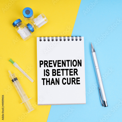 Foto A syringe, ampoules and a notebook with the inscription - prevention is better t