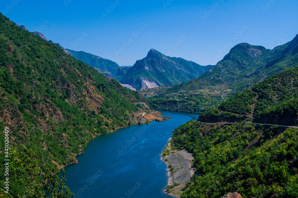 Beautiful summer landscape with blue river water in Albanian mountains, covered with lush foliage