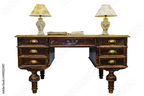 Antique writing desk, with table lamps, magazines and brochures. Isolated on white background