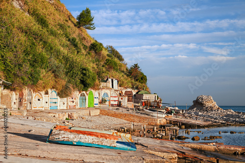 Fototapeta Naklejka Na Ścianę i Meble -  Ancona, Marche, Italy: the metropolitan beach of Passetto with the colorful doors of the caves carved into the rock to shelter the fishing boats